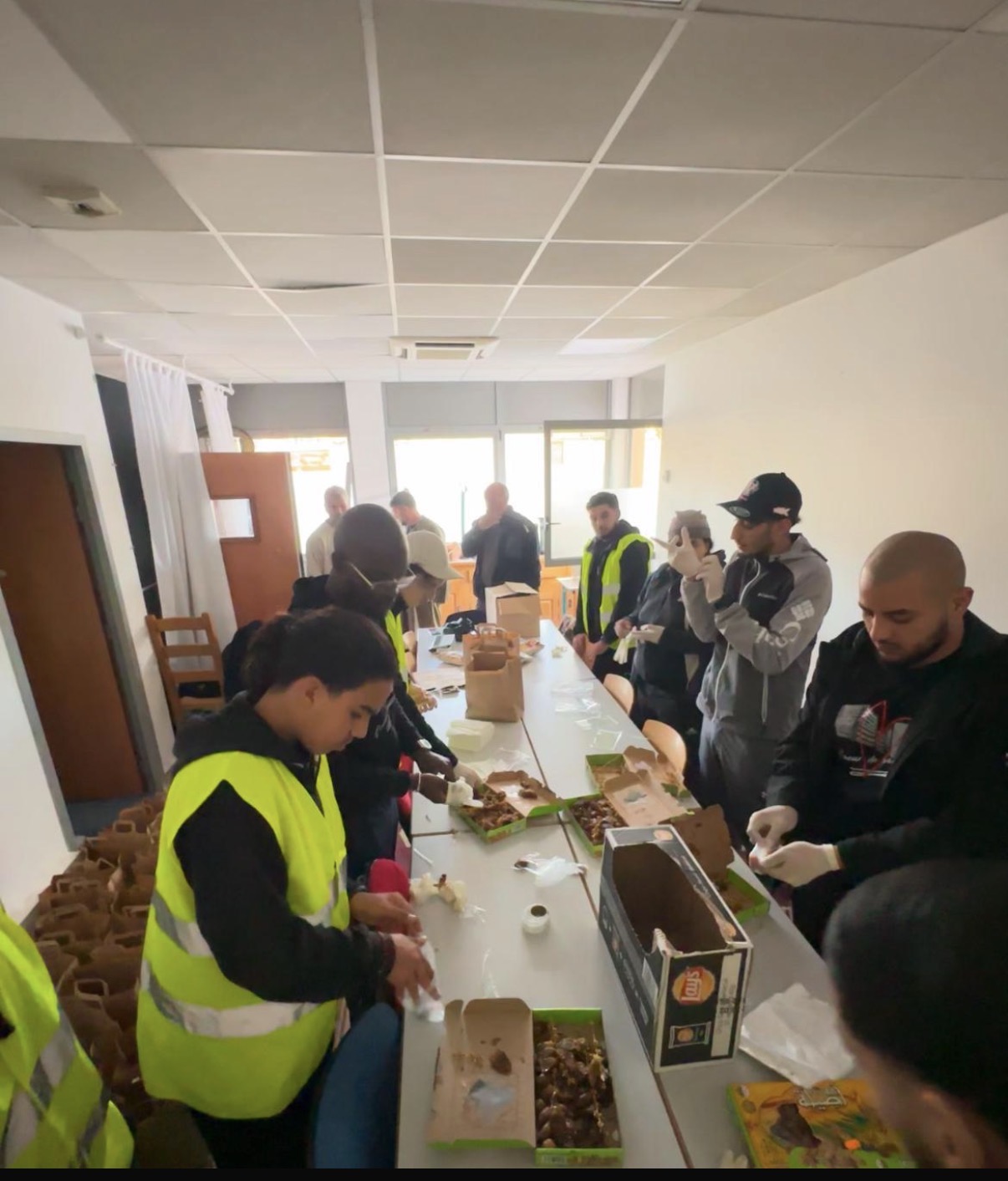 Des bénévoles préparent des repas et des produits à distribuer.